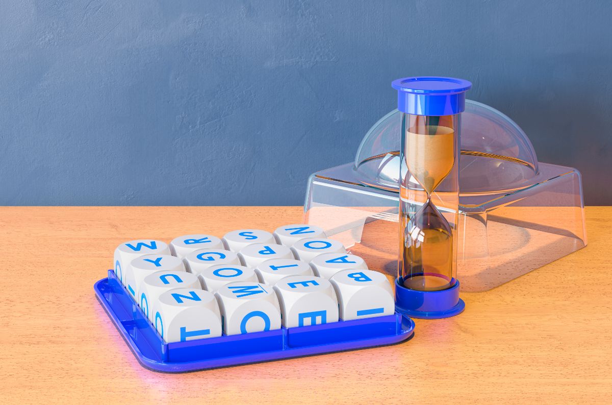 on a wooden table is a boggle set, with a sand timer