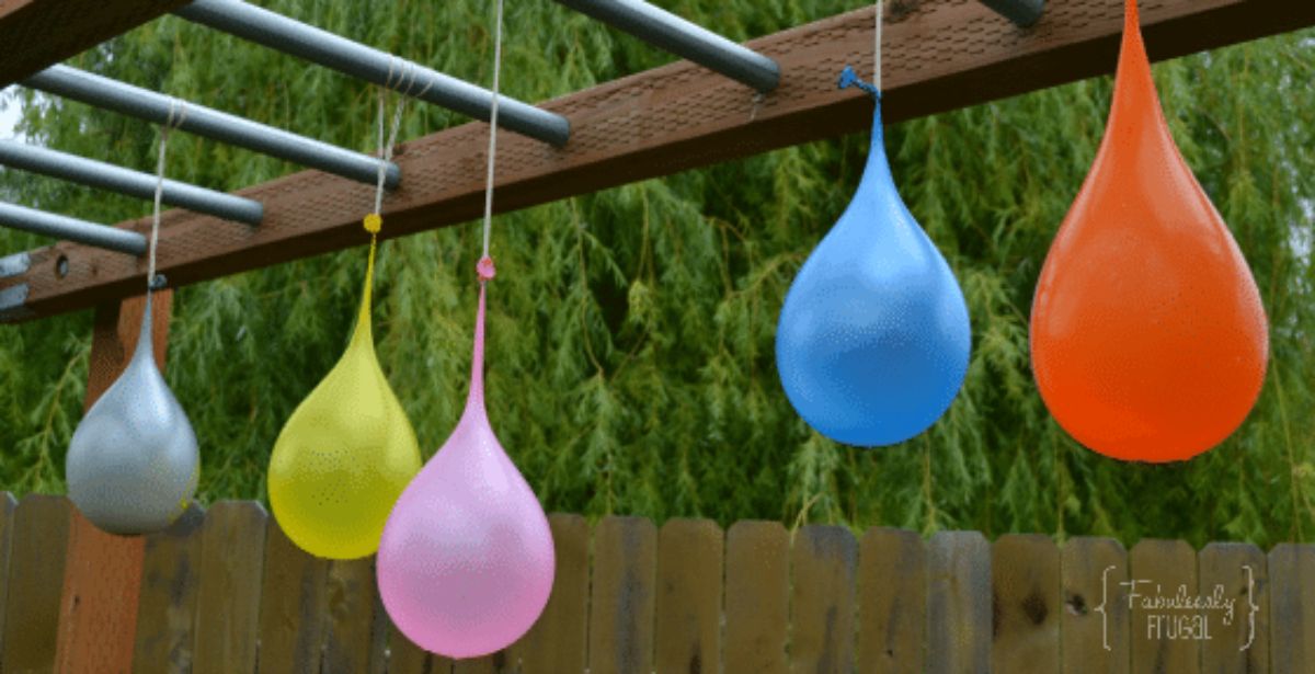 hanging from monkey bars are 5 filled water balloons