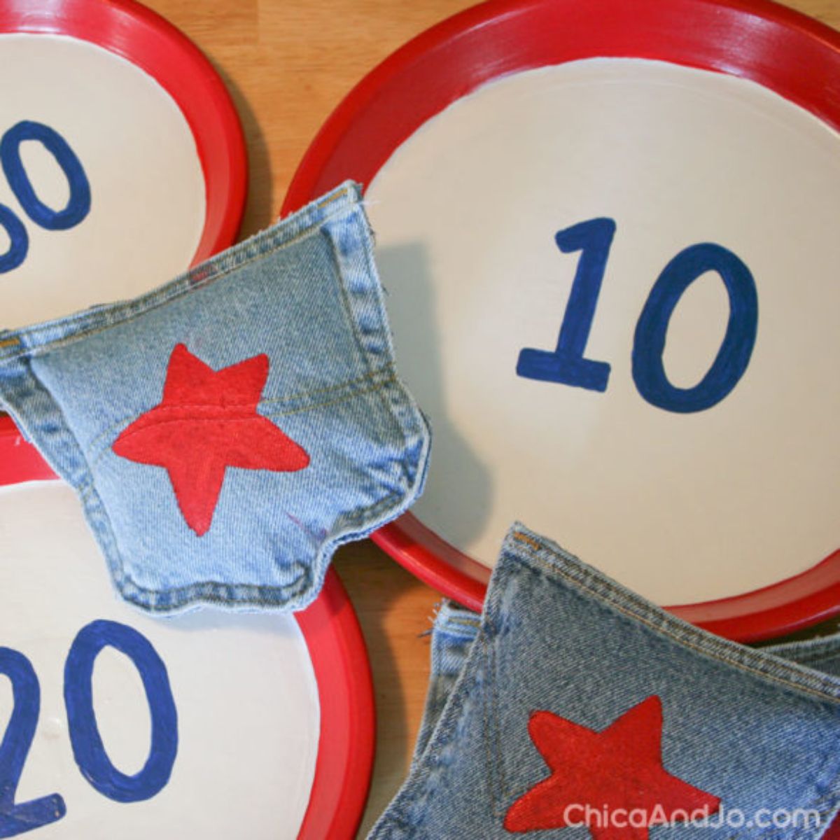 3 red paper plates with "10" "20" and "30" on them. 2 bean bags made out of denim