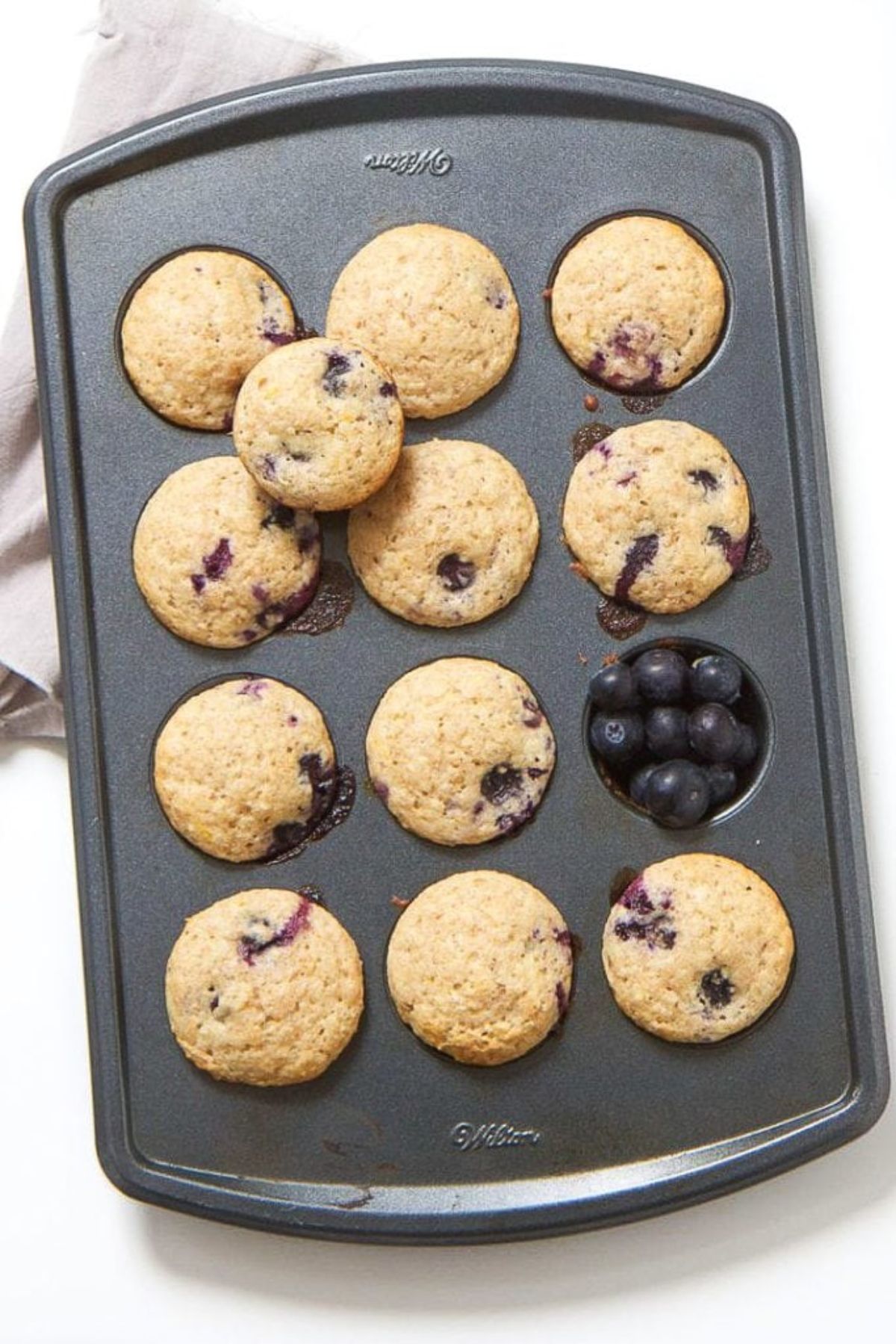 a muffin tray filled with blueberry muffins