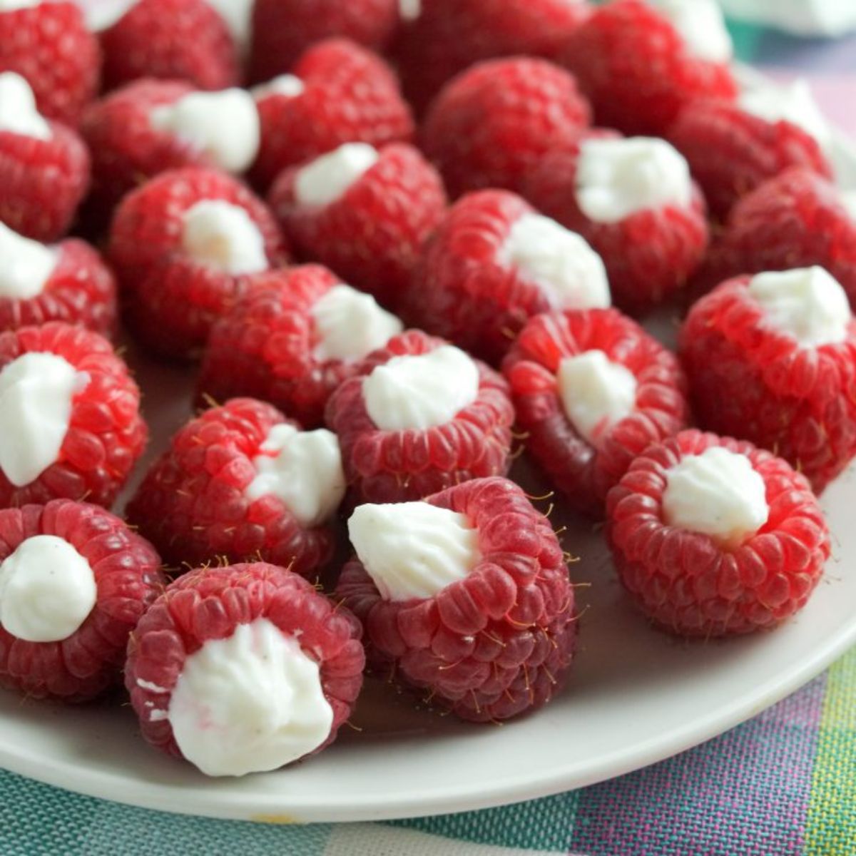 a plate of raspberries filled with yoghurt