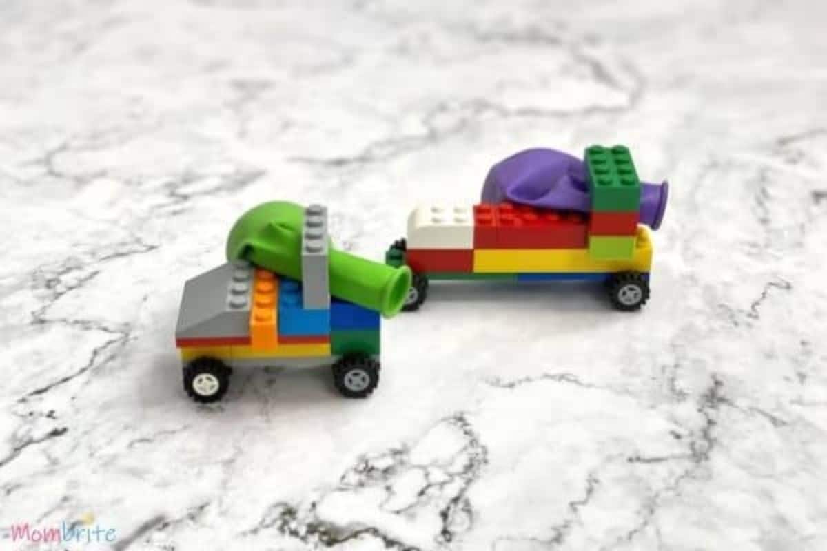 2 lego cars with deflated balloons attached to them