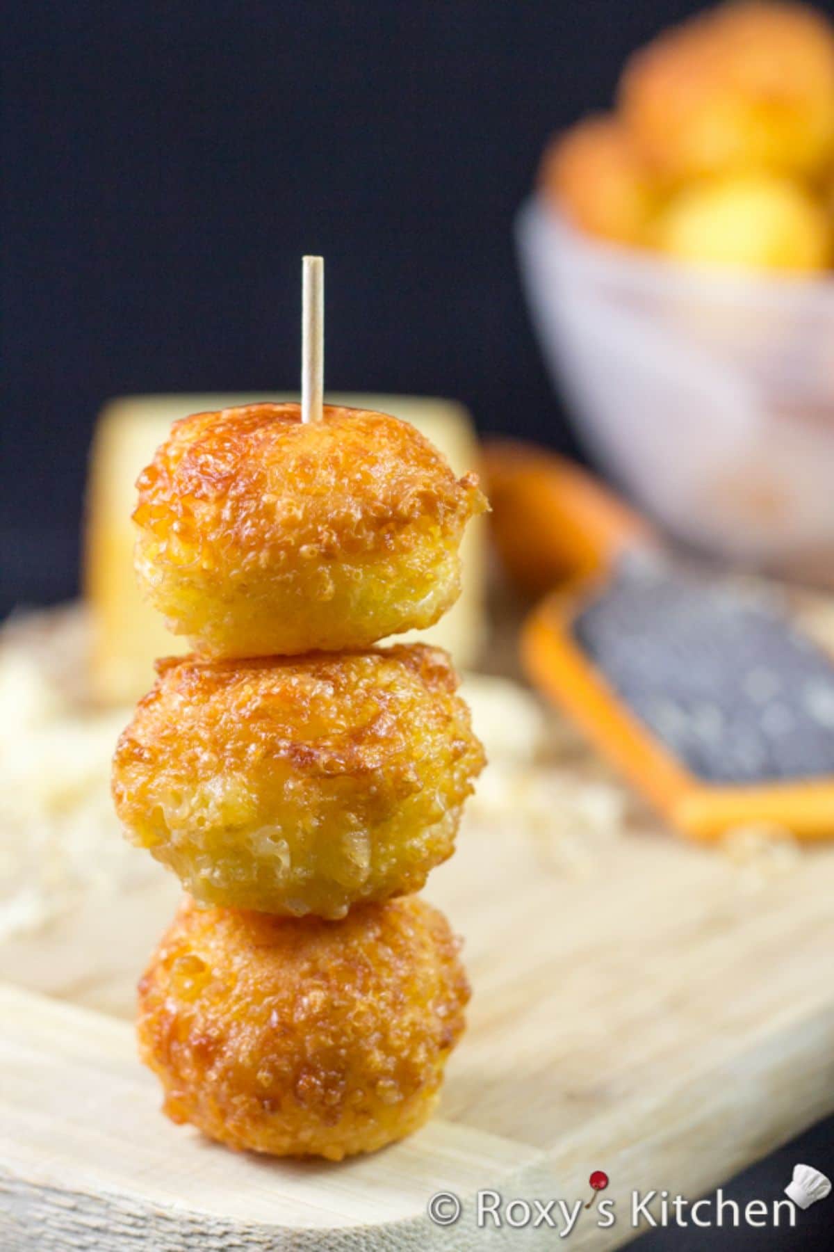 3 cheese balls are stacked on a skewer.