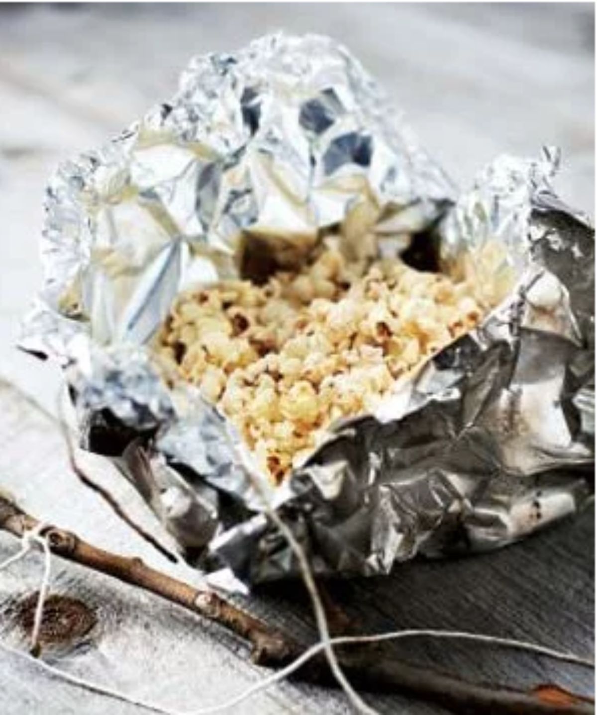 on a table is a parcel of tin foil containing popcorn