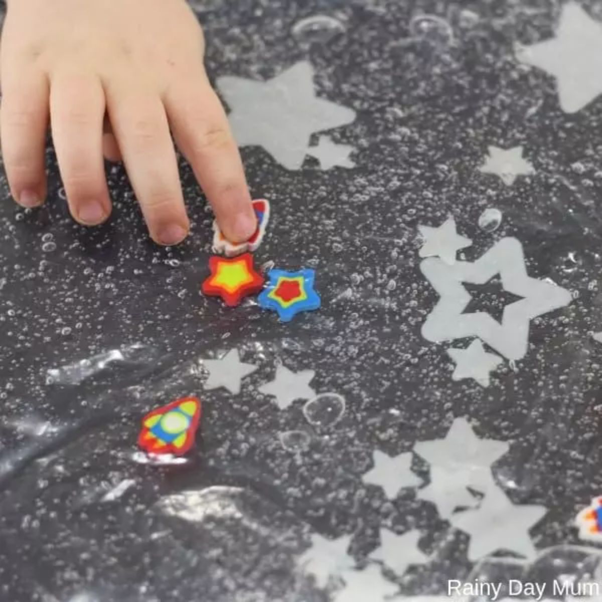 a hand reaches into a bag filled with star shapes