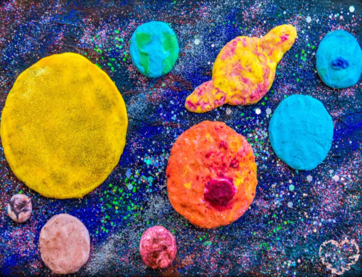 playdough planets are laid out on a starry sky