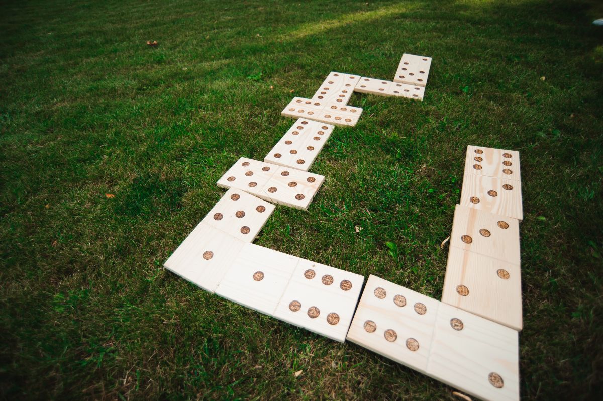 on a patch of grass are giant dominoes made of wood, placed as if in the middle of a game