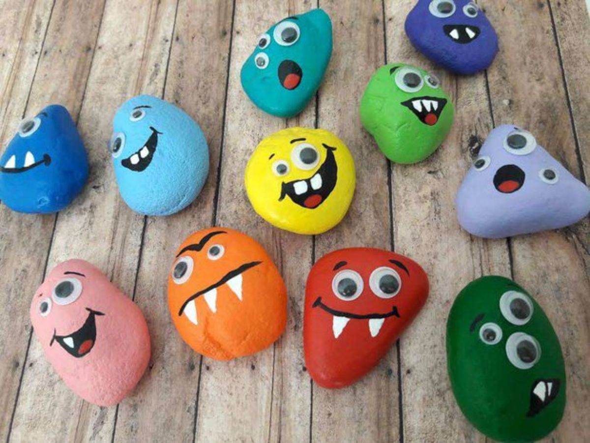 stones have been painted different colors and decorated with monster faces