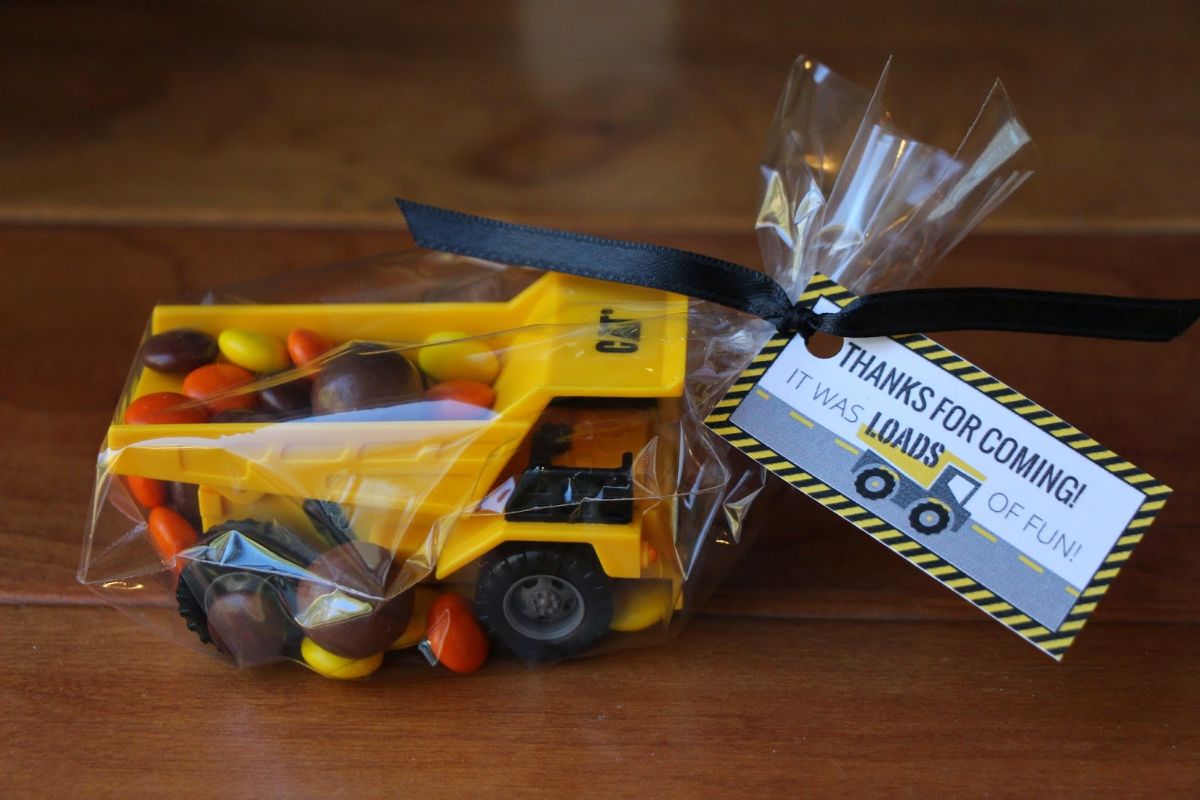 a wrapped toy yellow dumper truck is filled with sweets and a label is attached reads "Thanks for coming! It was loads of fun!"
