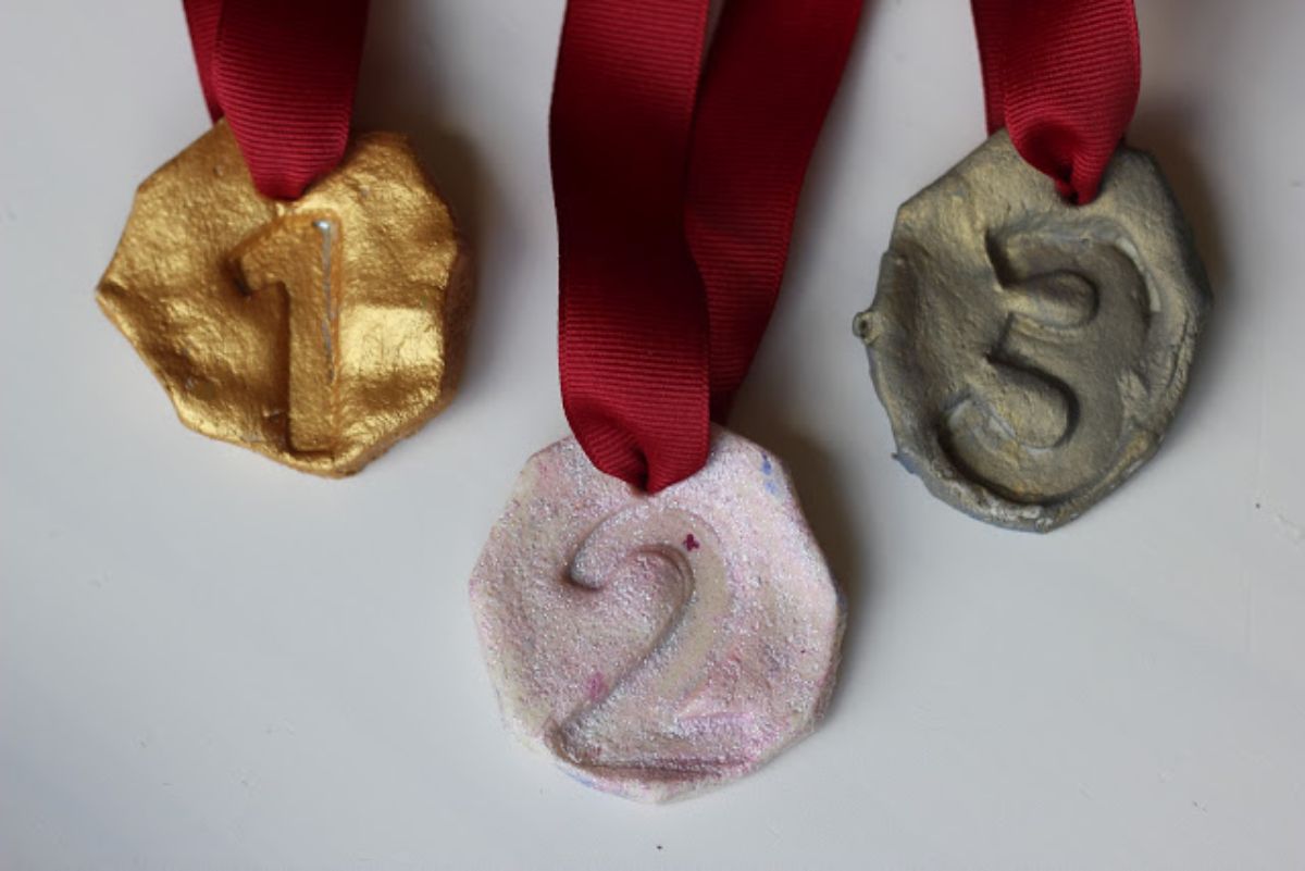 salt dough medals colored gold, silver and bronze hanging from red ribbons
