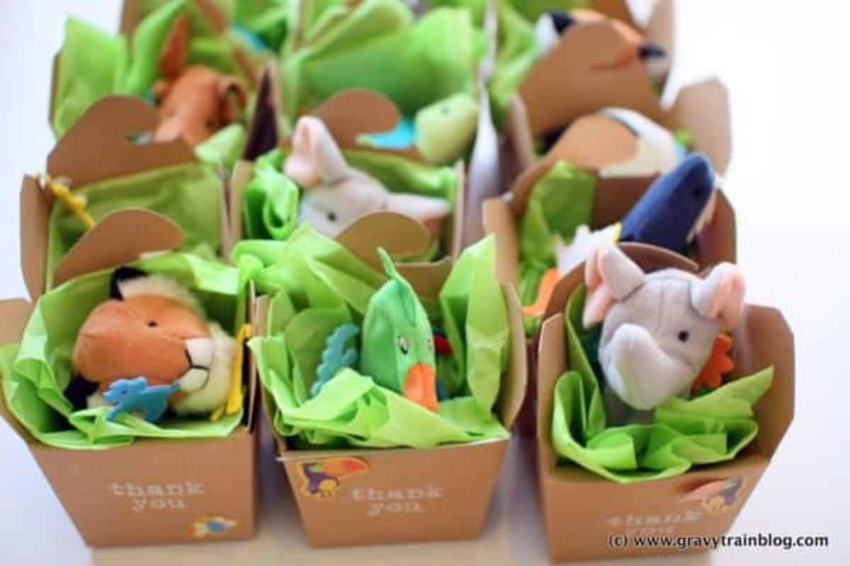 9 brown paper cartons lined with green tissue paper and filled with stuffed animals