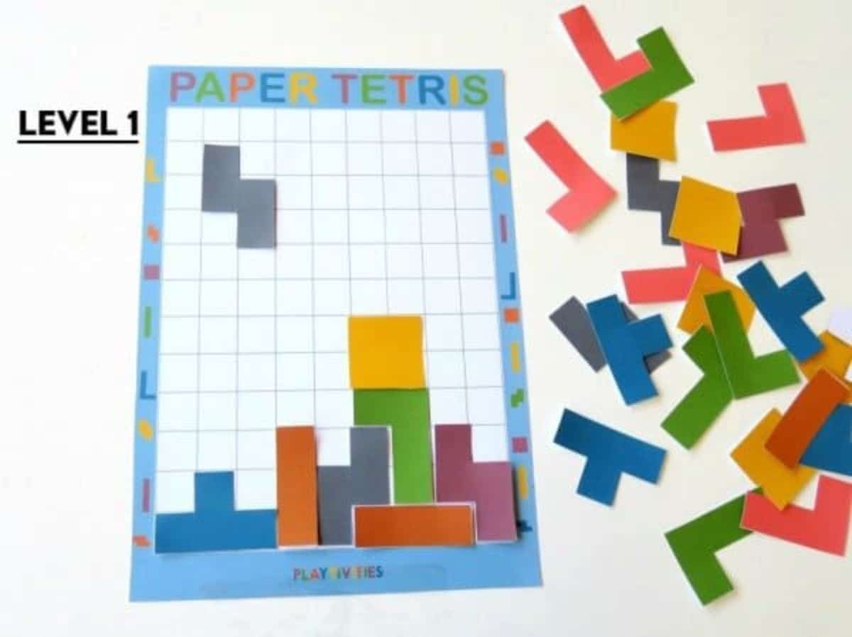 a piece of paper with "Paper Tetiris" on the top has been divided into squares. Colored block shapes have been fitted into the grid adn spare shapes sit to the side