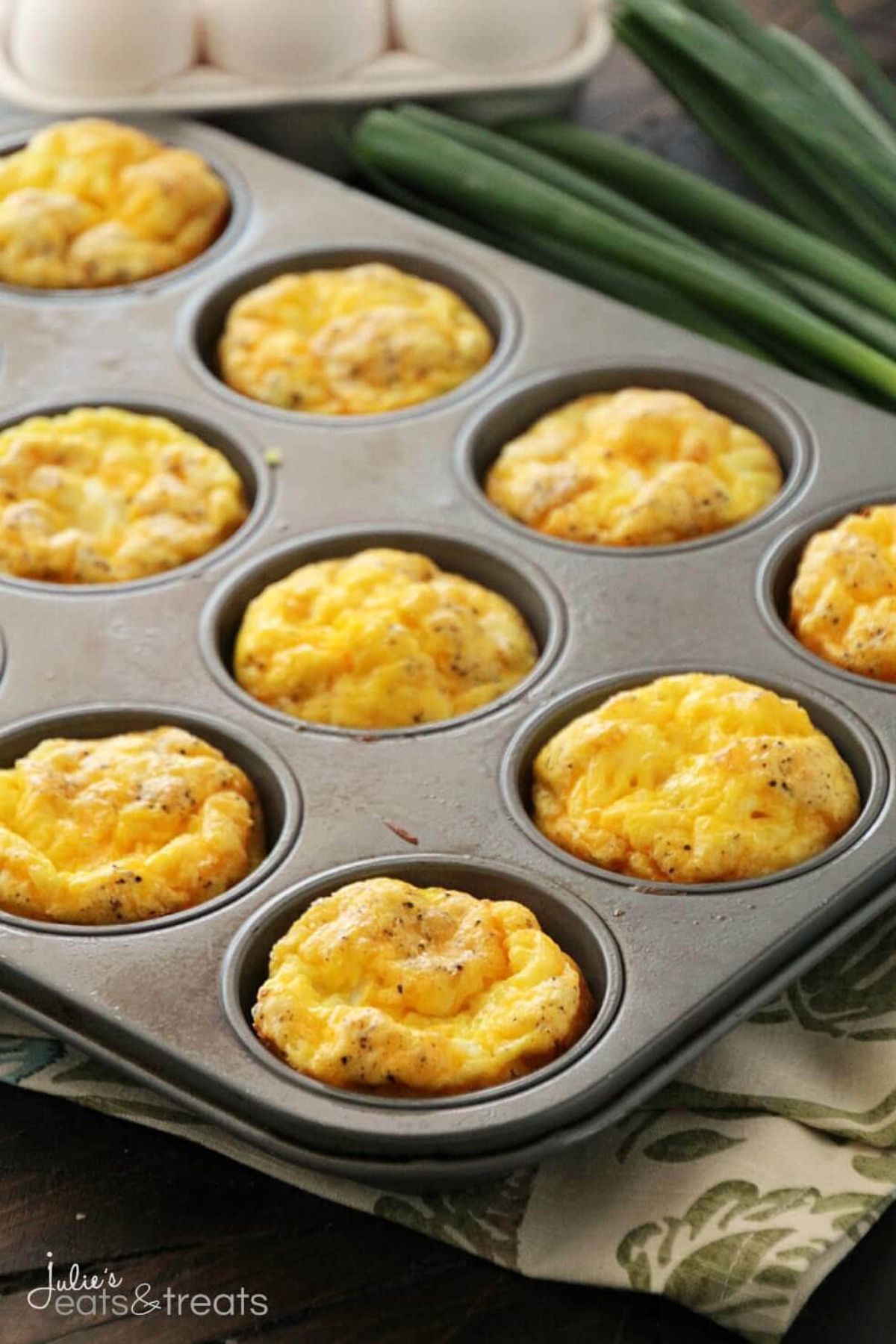 a muffin tray filled with ham and cheese egg muffins