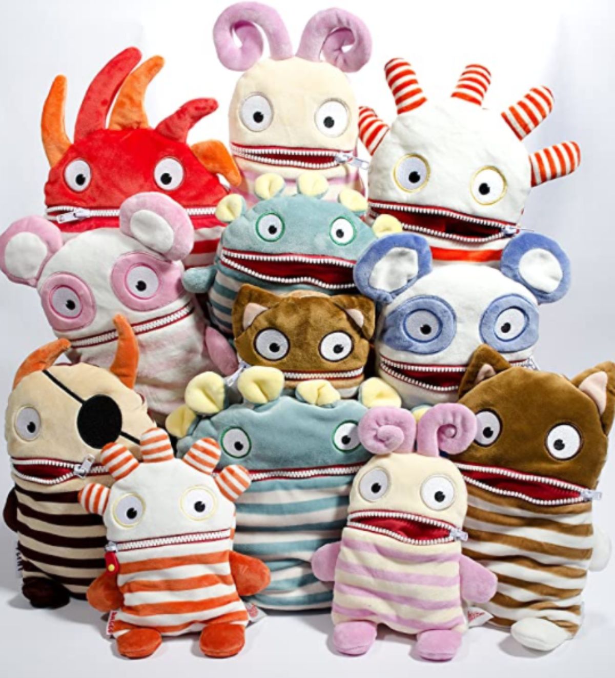 a group of soft toy monsters, ech with a zipped mouth face the camera