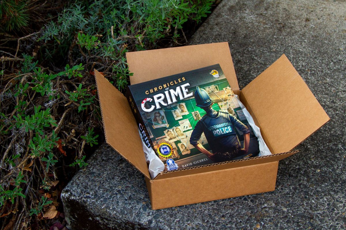 cardboard box on sidewalk with crime game out of top of box