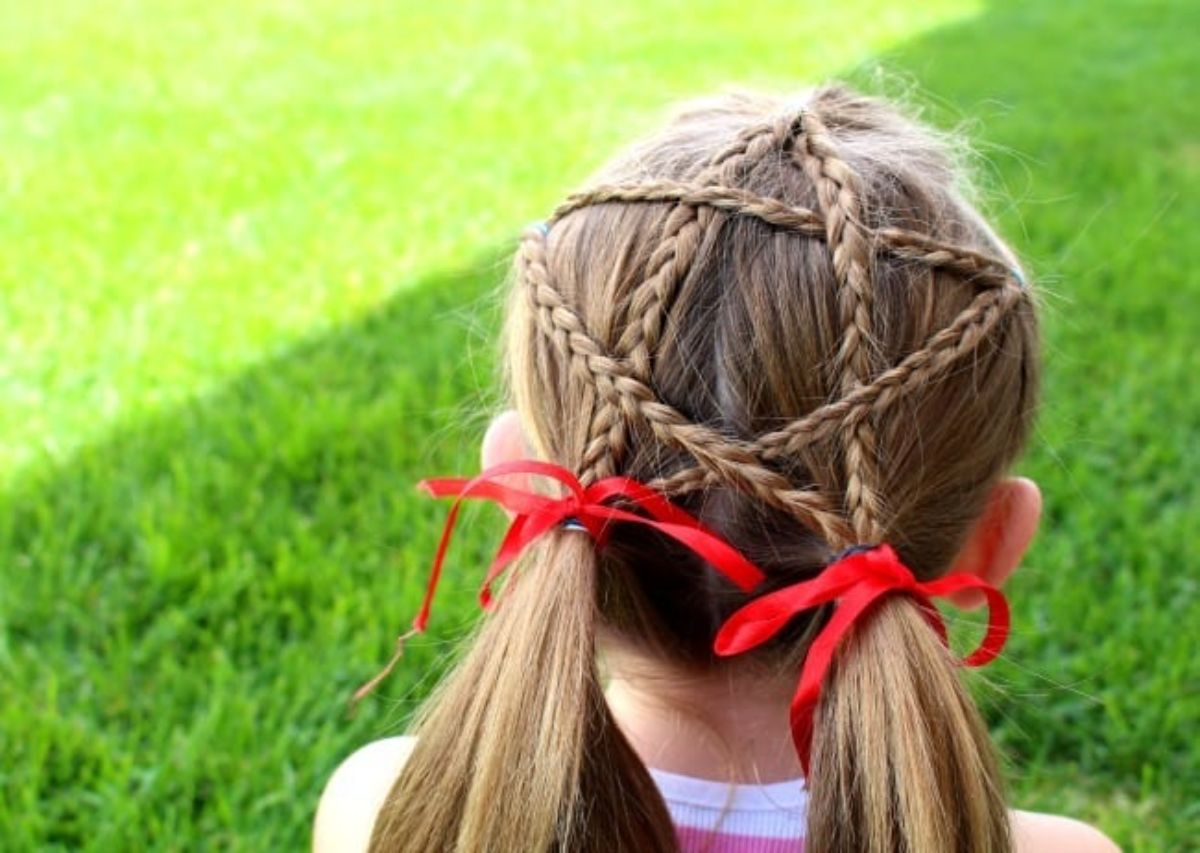 Young girl with a star type hairstyle with two red ribbons.