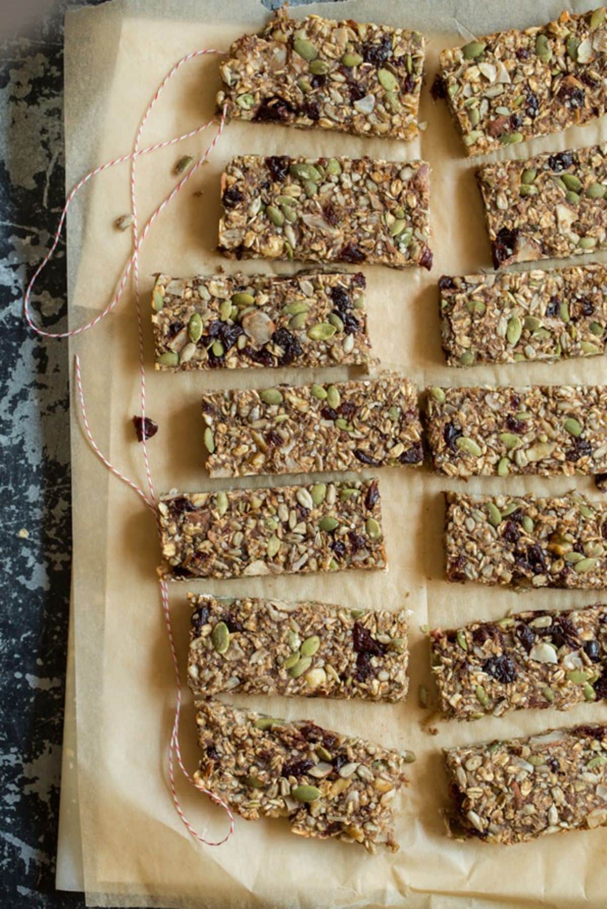 Bunch of granola bars on a parchment paper on a table.