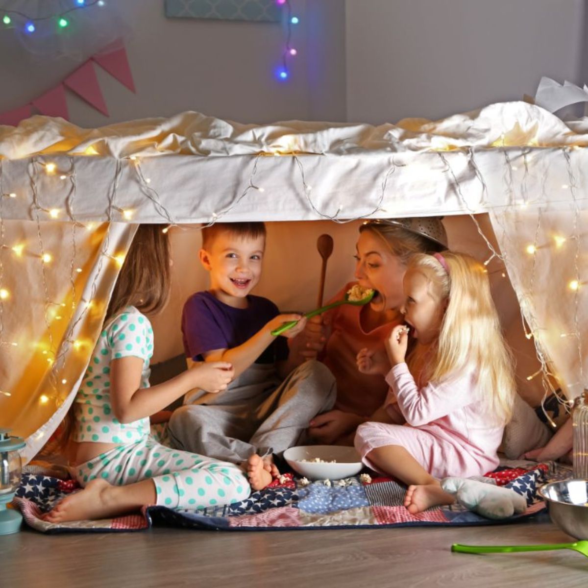 Young kids playing in a living room fort.