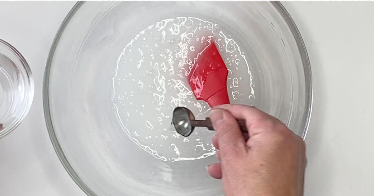 adding activator to a bowl of slime supplies to make Penguin Ice Cube Slime