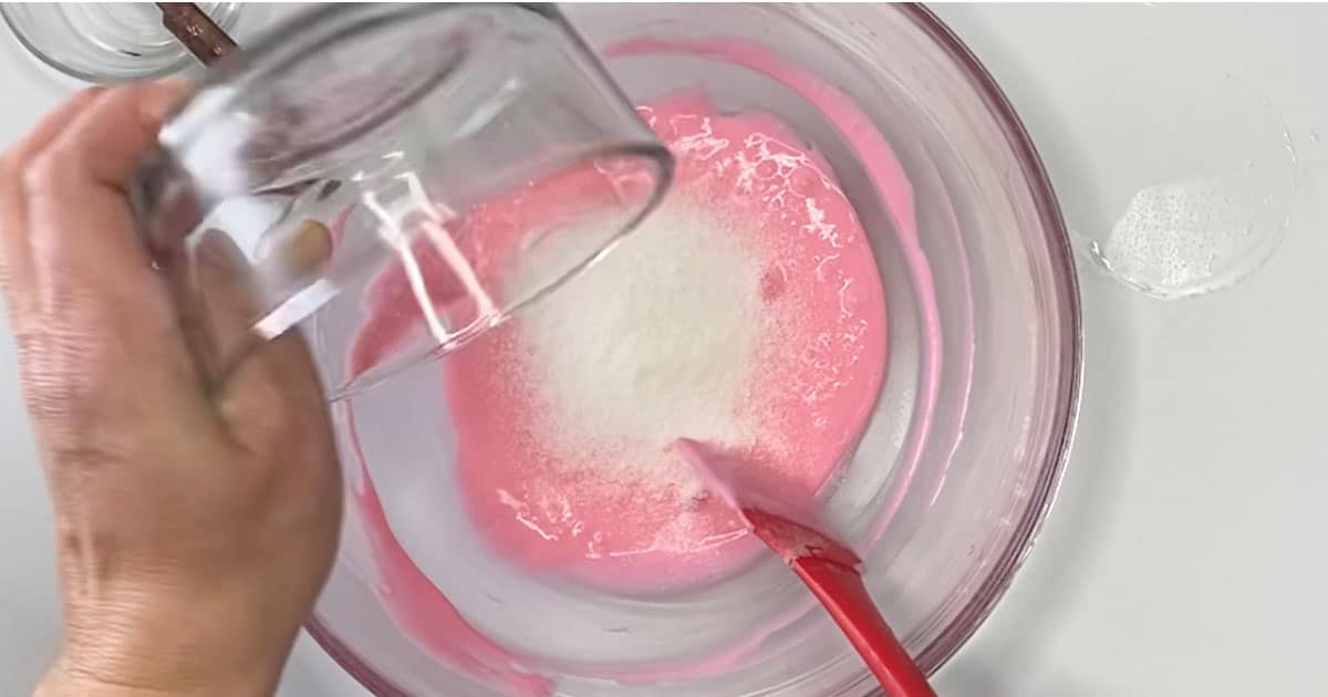 adding fake snow to other supplies to make Strawberry Milkshake Slime