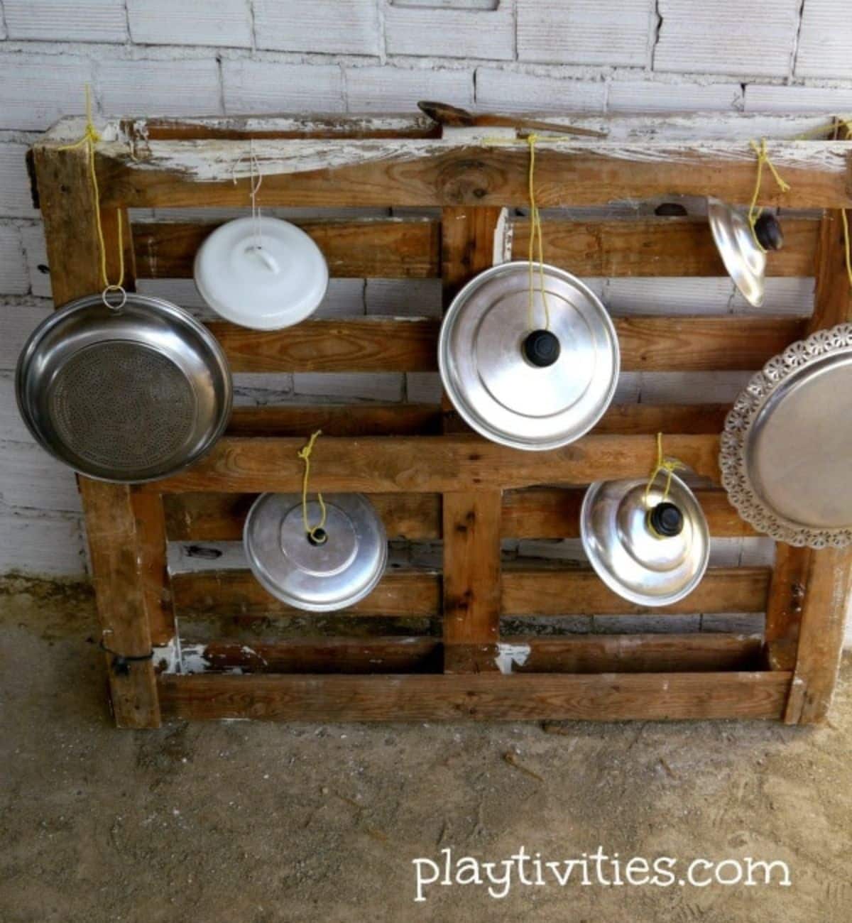 Homemade Drums from Pot Lids on w wooden palet.