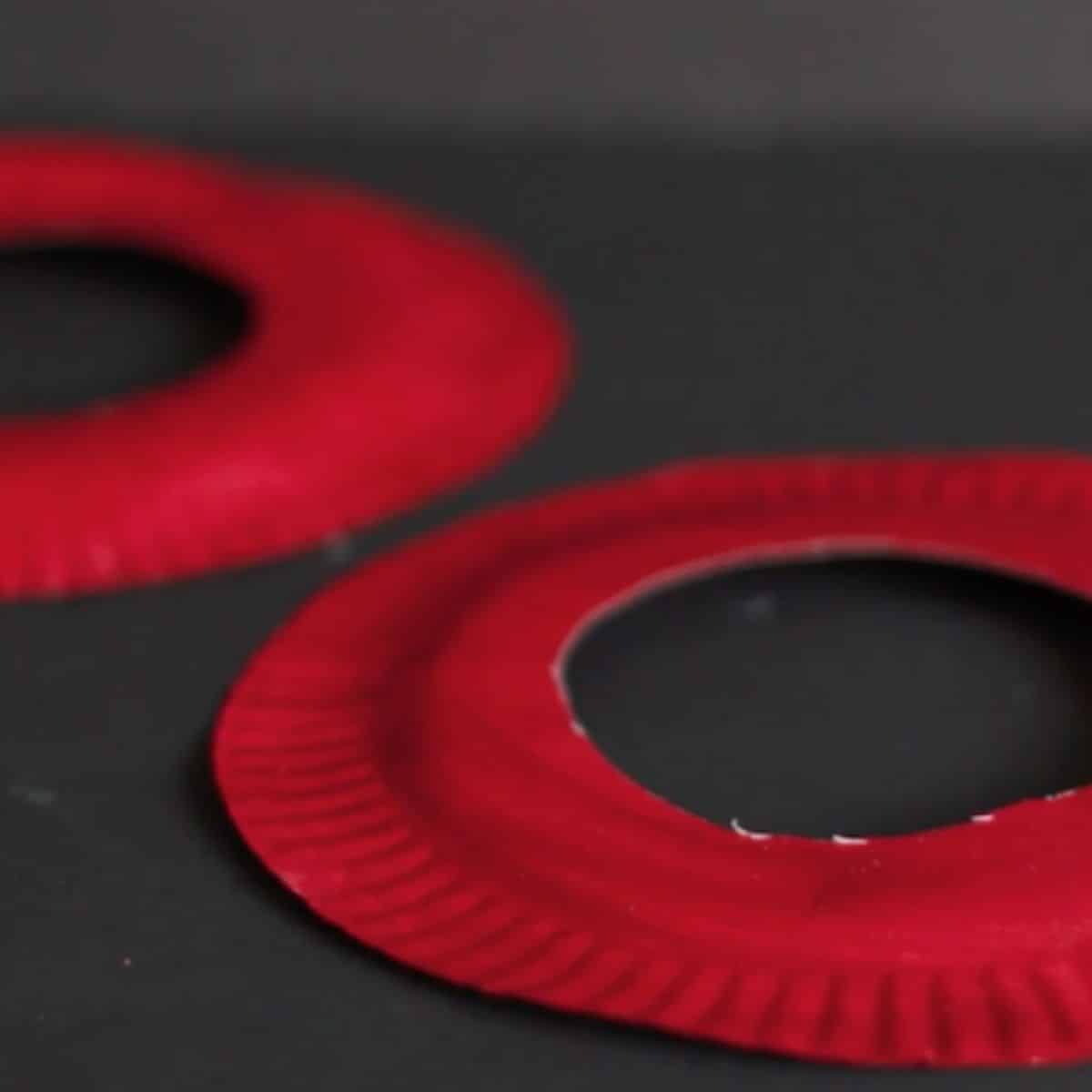 Red Paper Plate Discs on Black Background